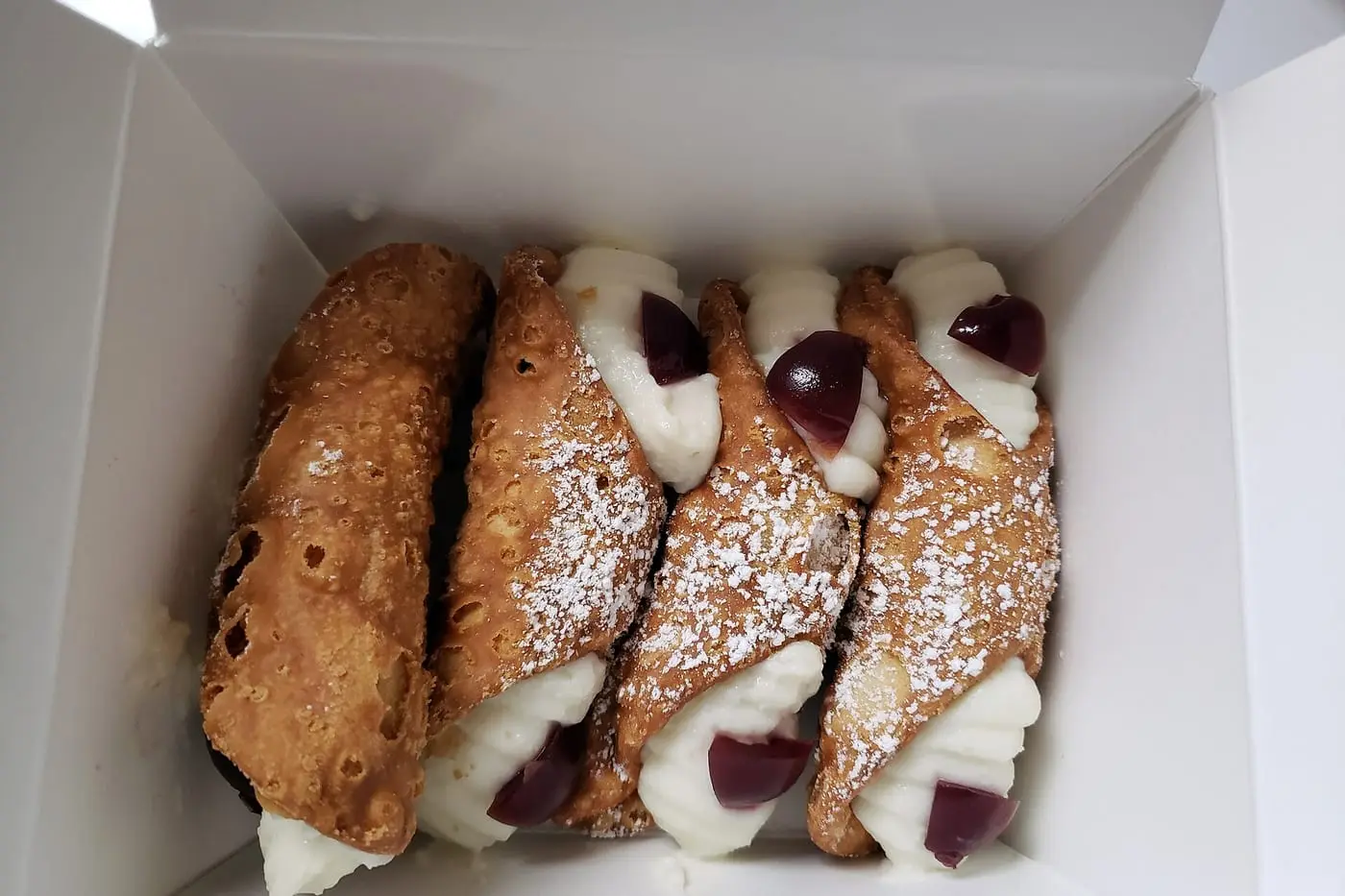 Cannoli siciliani fritti in una scatola, con ricotta e ciliegia candita
