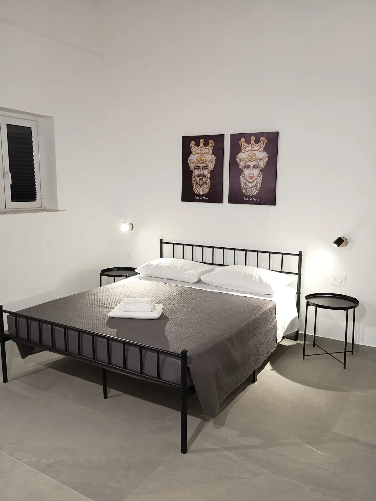 Camera da letto con letto matrimoniale, pareti con quadri e televisione