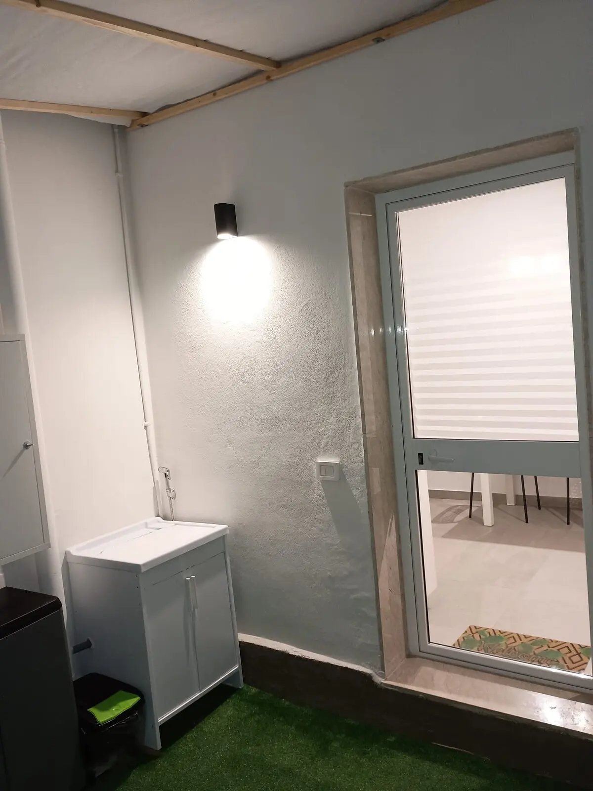 Angolo del cortile interno con finestrella, luce a muro e climatizzatore