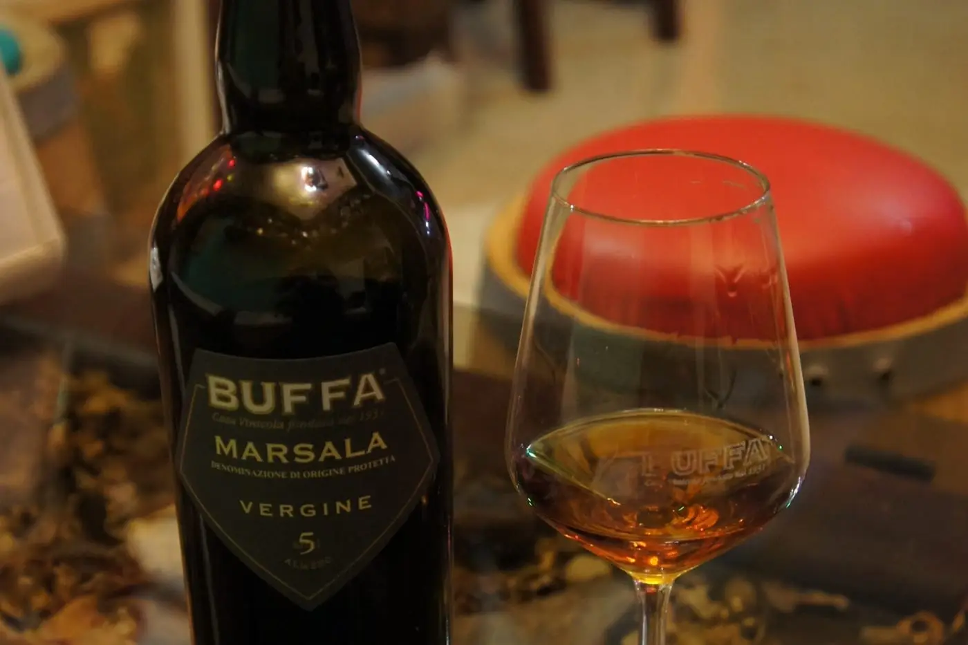 Bottiglia di Marsala Vergine con un calice di vino accanto