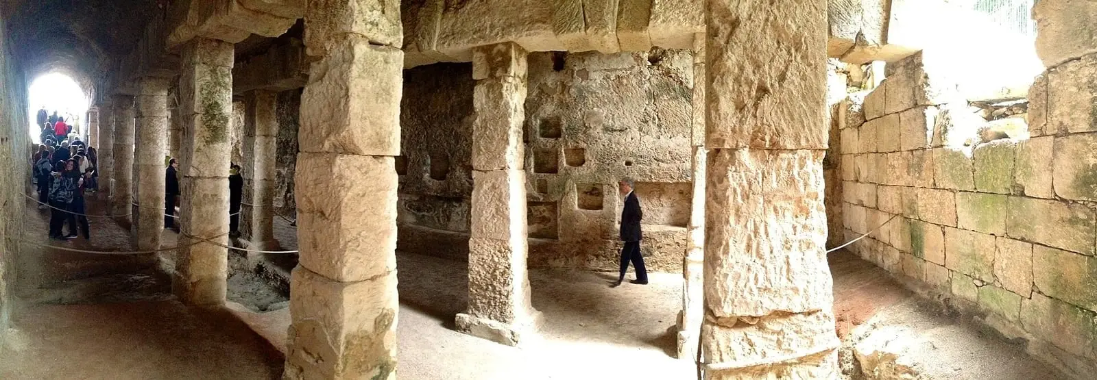 I grandi pilastri di pietra della Piscina Romana, con una persona in mezzo