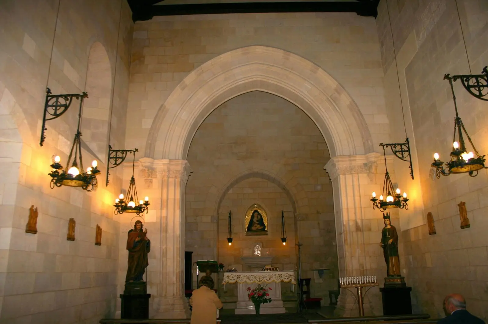 L’interno di Santa Maria dei Miracoli, con l’arco, le lampade e l’altare